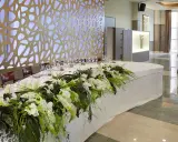 Elegante mesa presidencial boda con arreglos florales blancos y verdes, velas y copas.