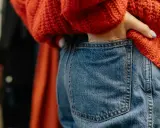 Persona mete la mano en el bolsillo de sus vaqueros. Un truco para lavar vaqueros con vinagre es añadirlo al ciclo de enjuague.