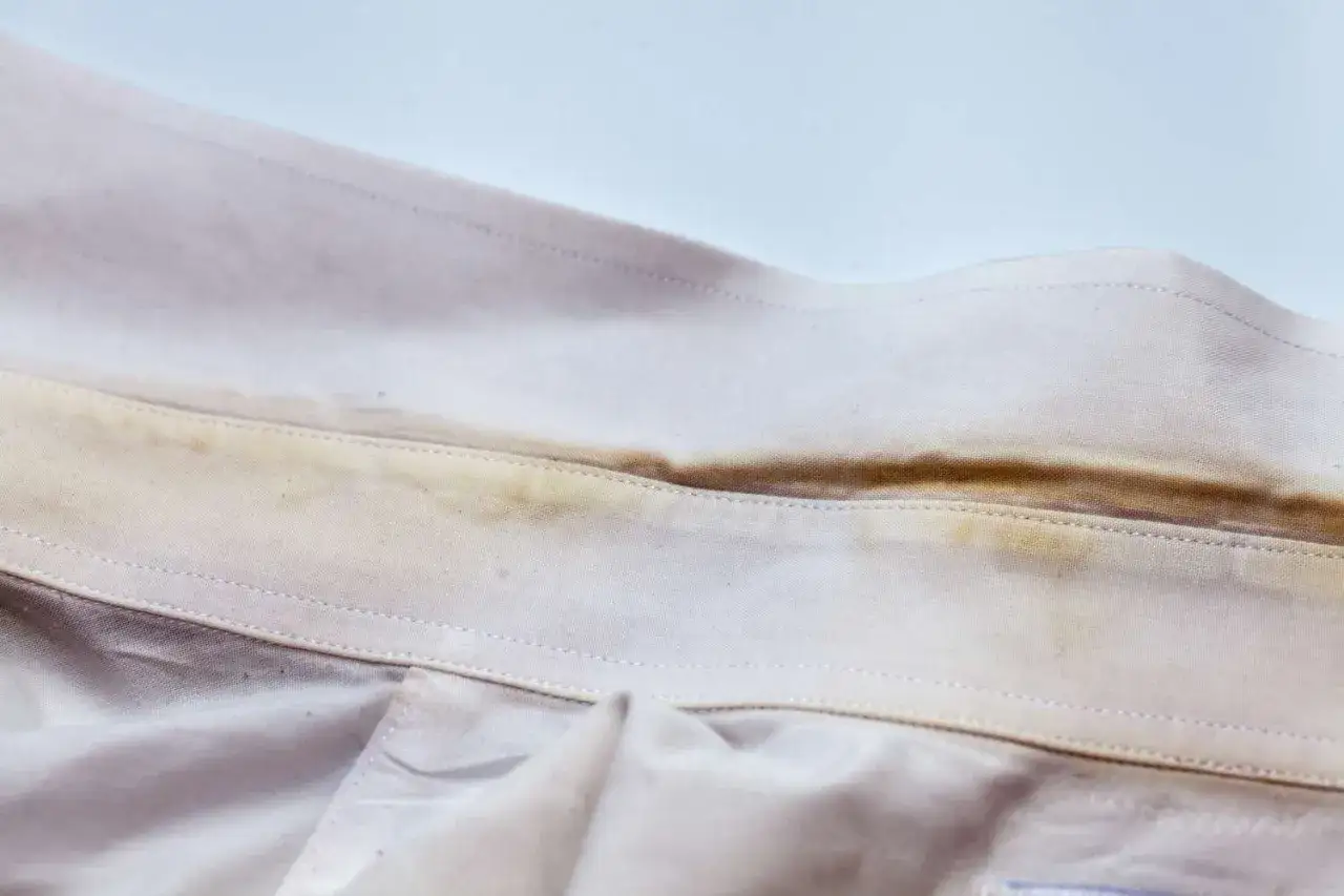Cuello de camisa blanca con manchas amarillas, un ejemplo de cómo quitar manchas amarillas de ropa blanca.